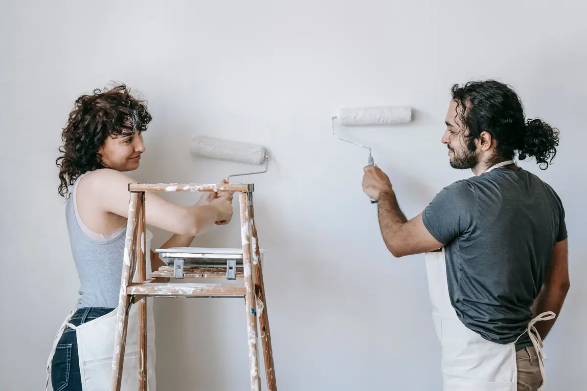 People painting a wall together — painting help in Topeka